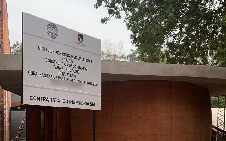 Edificio de sanitarios terminado, con el cartel de obra que indica como contratista a CQ Ingeniería SRL