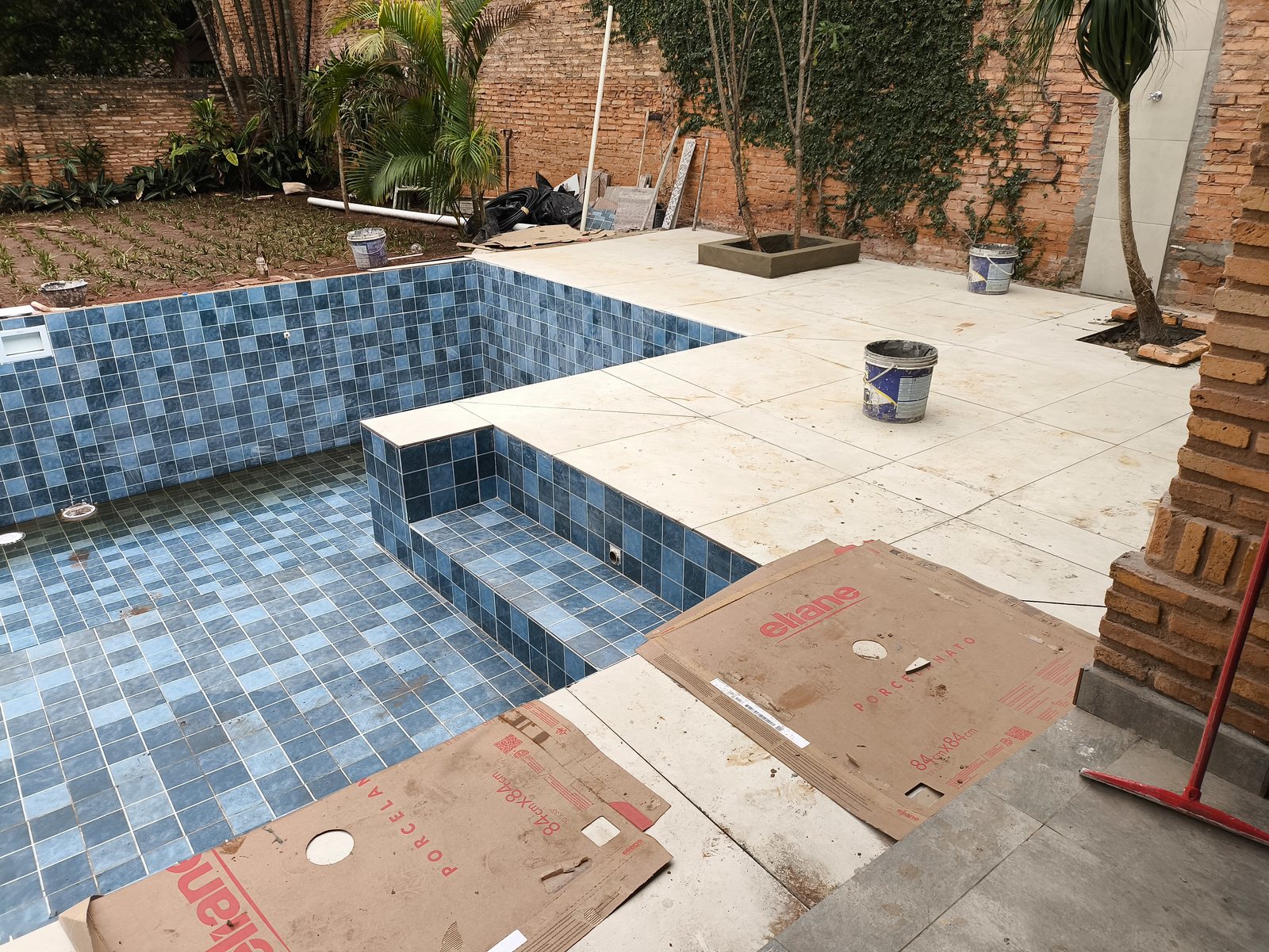 Piscina con fondo y escalones revestidos y solárium de losetas