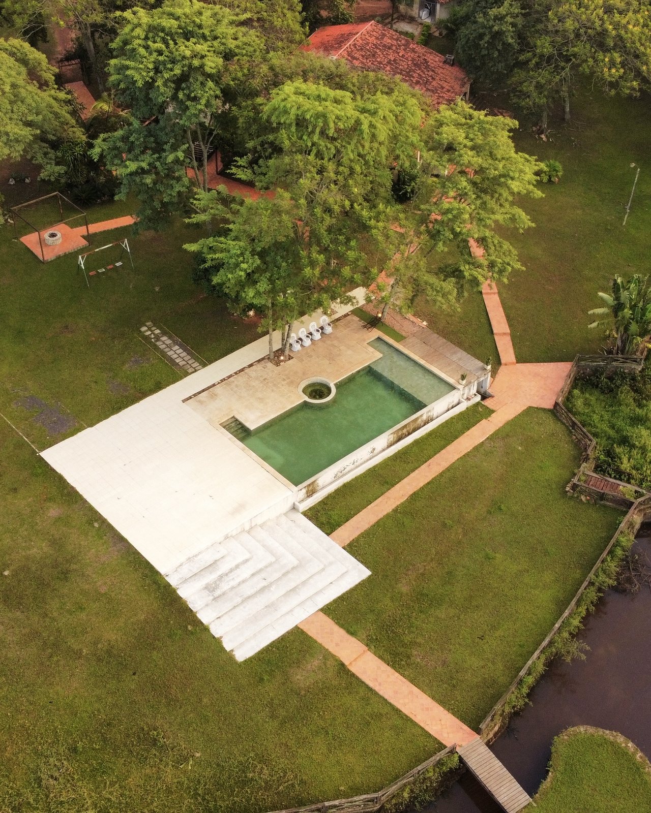 Vista aérea de Ára Lodge: piscina con hidromasaje, solárium, escalinata, camineros, fogón y parque