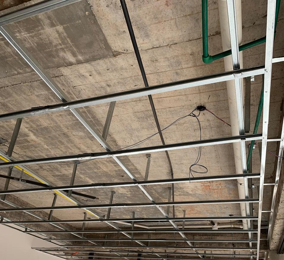 Estructura metálica del cielorraso colocada bajo la losa, con las instalaciones a la vista